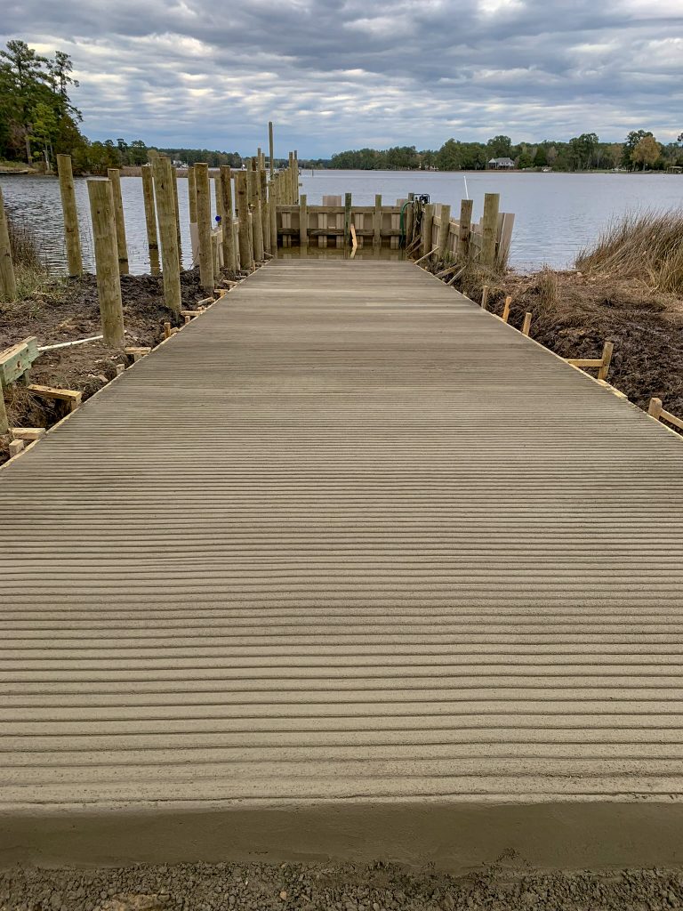 Newly poured concrete boat ramp leading to the water, built by Early Marine Construction