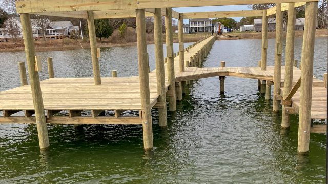 Long new pier with a covered boat slip being framed, built by Early Marine Construction