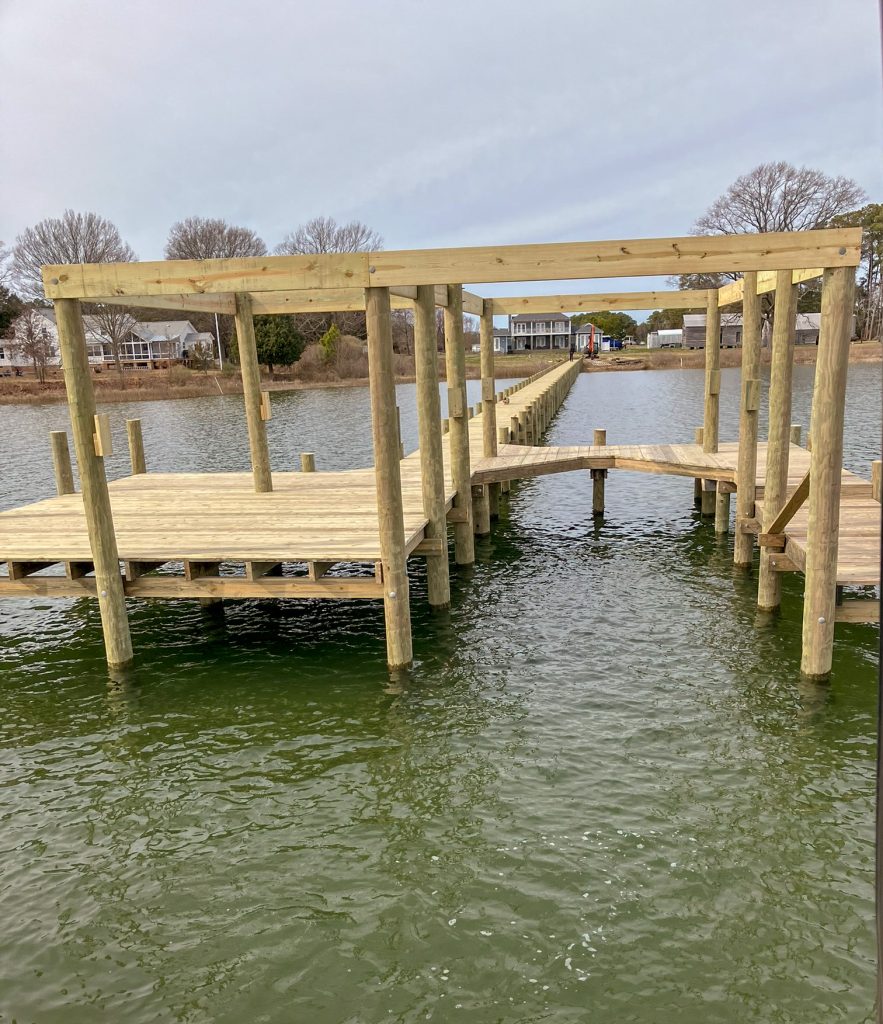 Long new pier with a covered boat slip being framed, built by Early Marine Construction