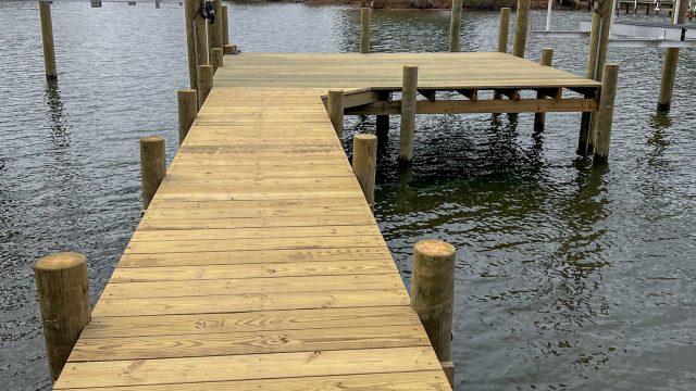 New wood pier with a T head and two boat lifts on a tidal creek, built by Early Marine Construction