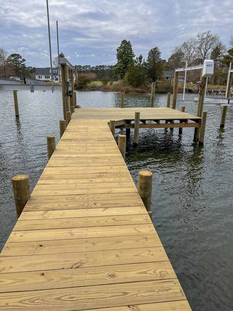 New wood pier with a T head and two boat lifts on a tidal creek, built by Early Marine Construction